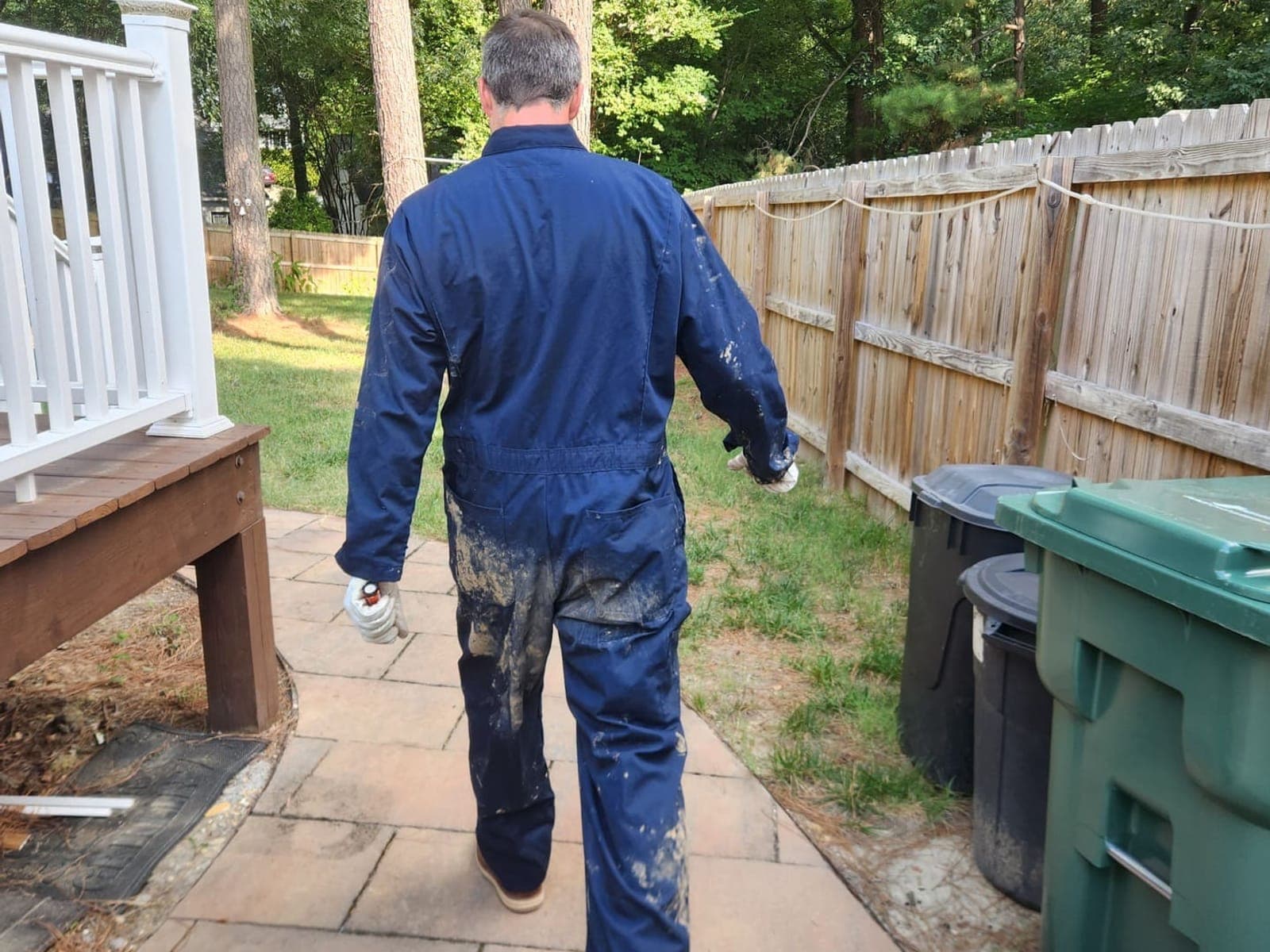 A-Team plumber in work coveralls walking back to the van after finishing an underground line repair