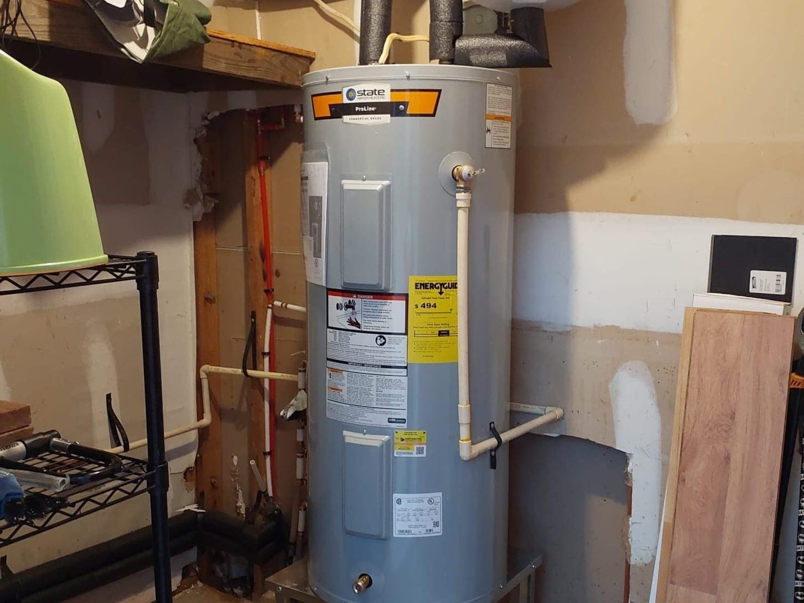 Newly installed State tank water heater with expansion tank and insulated supply lines in a Durham utility room